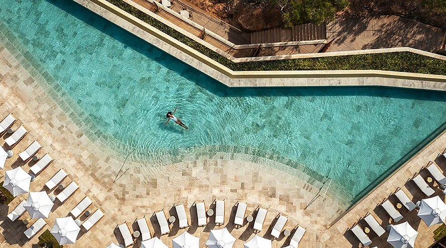 The clifftop pool and wellness pavilions of Six Senses Ibiza above the Balearic Sea