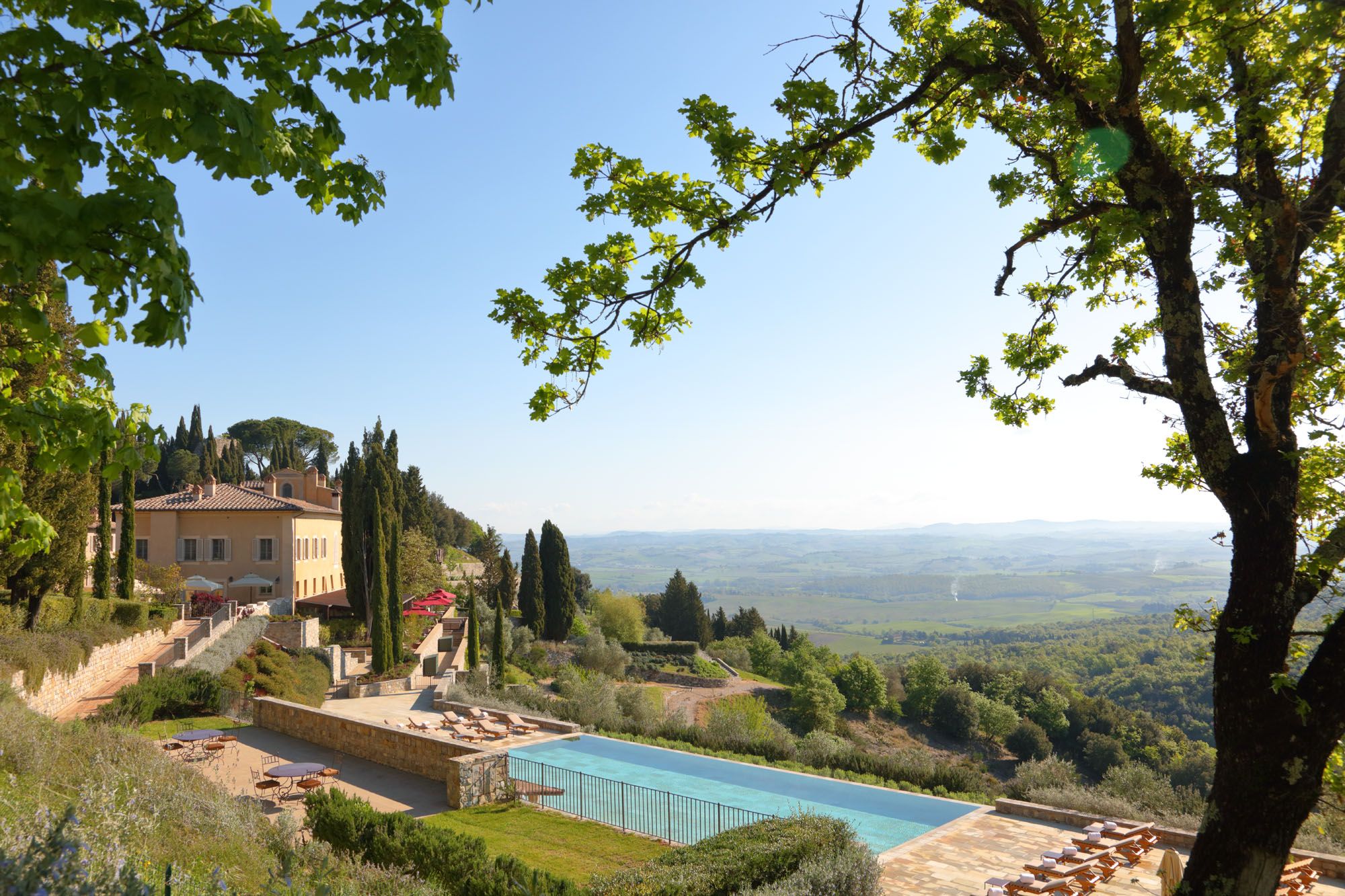 Castiglion del Bosco Tuscany stone farmhouse villa with infinity pool, cypress trees, rolling Tuscan hills
